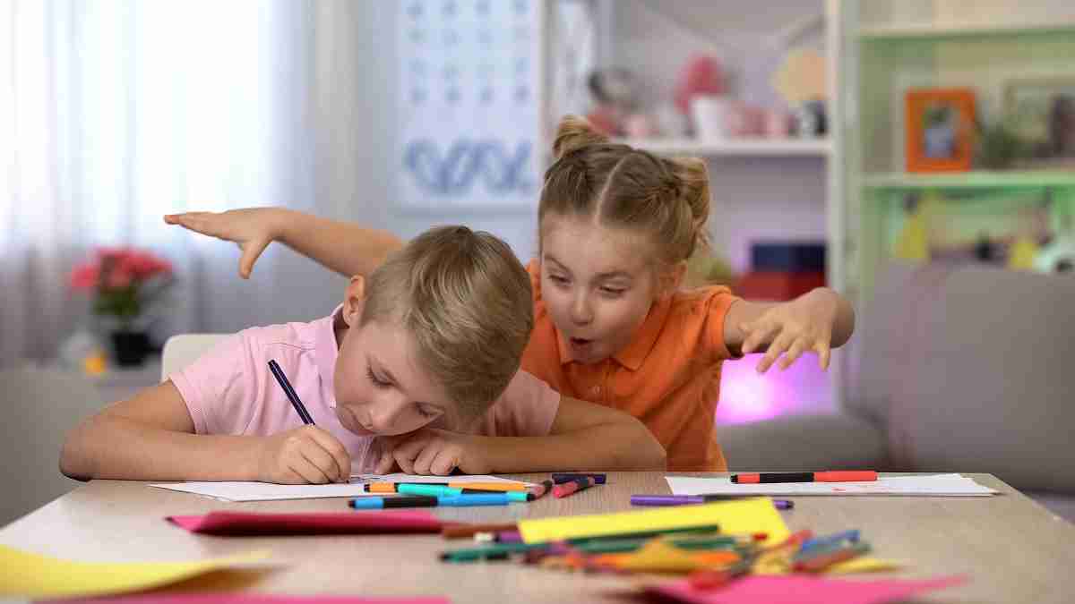 Niña trata de asustar a su hermano que esta estudiando